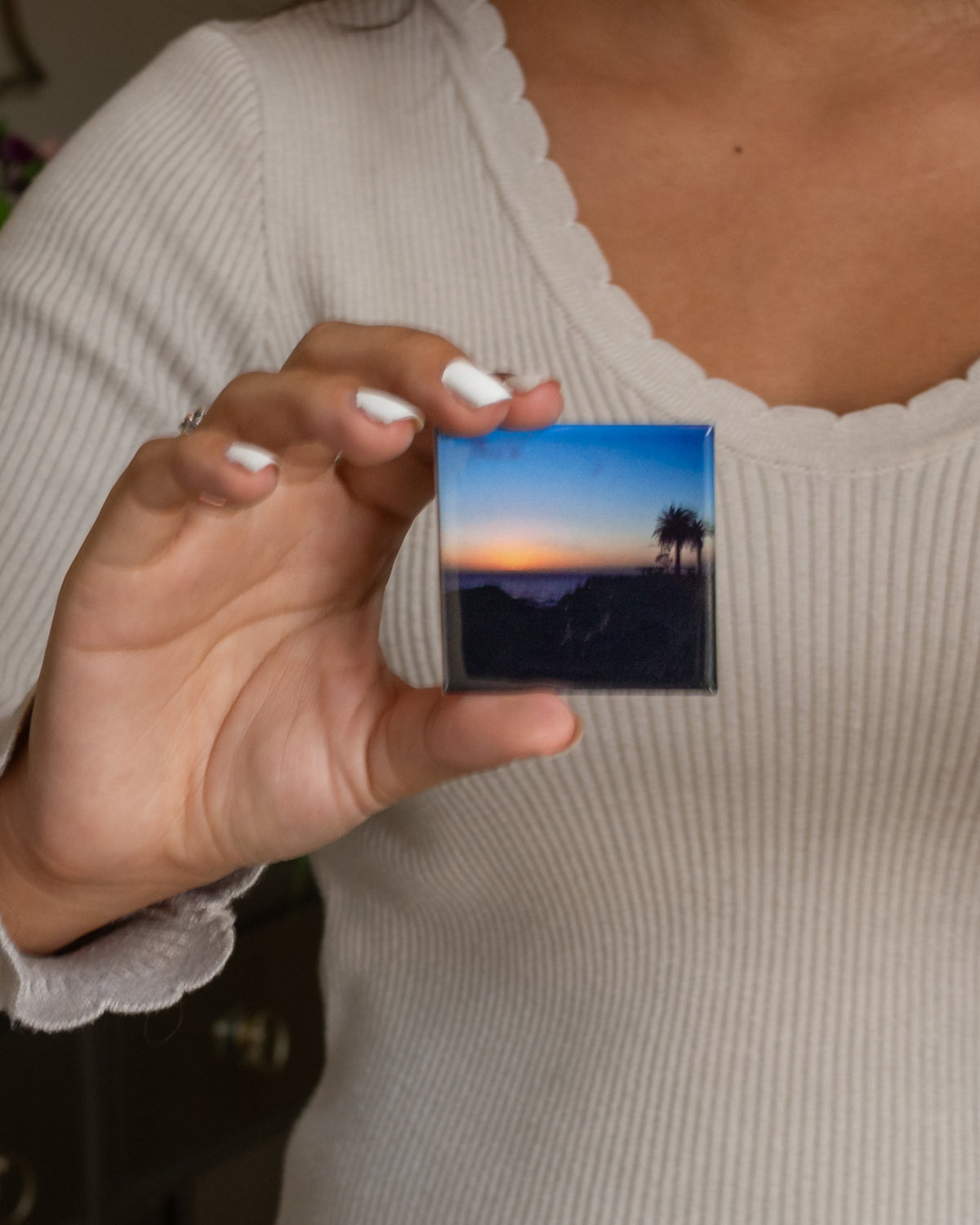 2x2 custom photo magnet held in hand for size reference