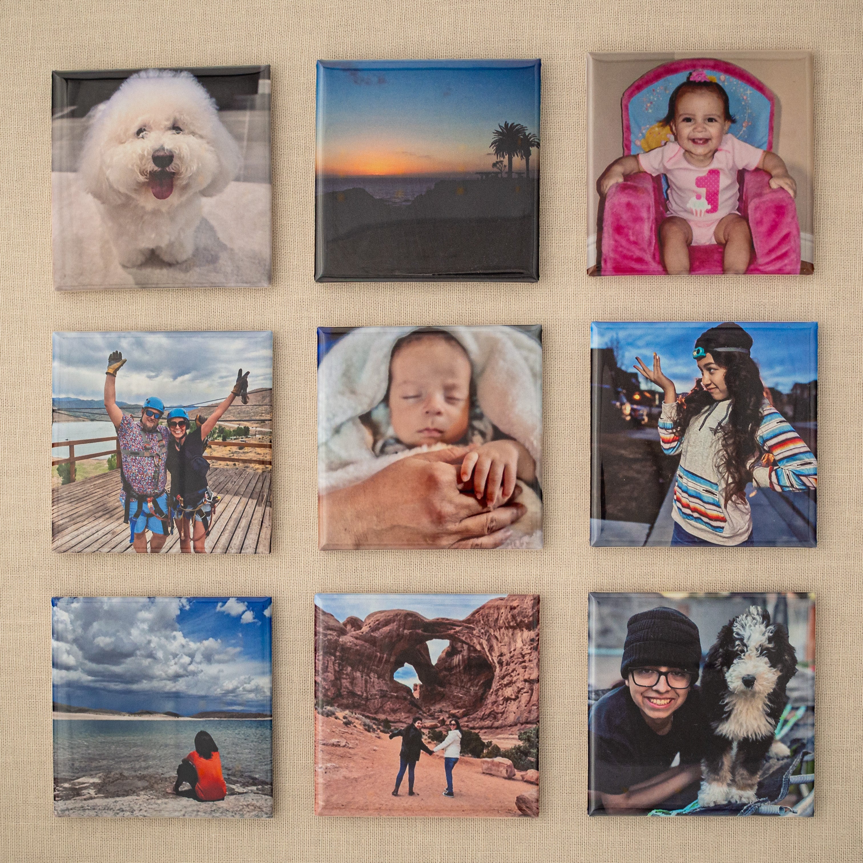 Set of nine custom 2×2 photo magnets arranged in a 3×3 grid on beige fabric.
